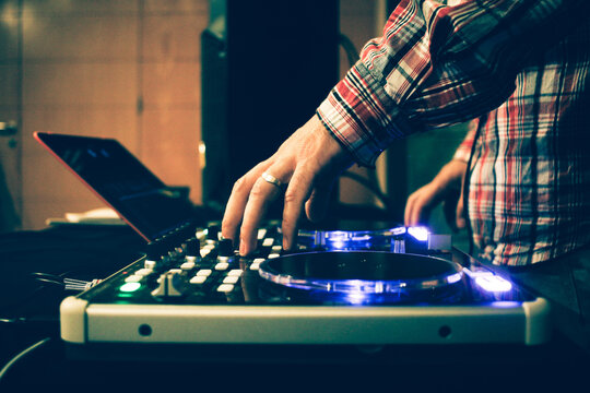 Deejay man playing his mixing board in a music session. Modern dj music.