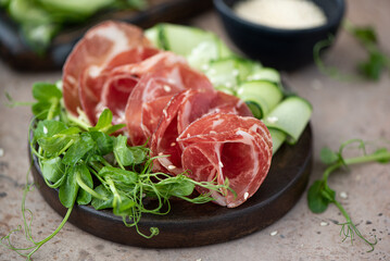 thin sliced bacon with vegetables on a wooden board
