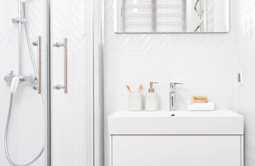 Shower cabin and washing basin in modern white bathroom interior