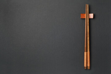 Top view of wooden chopsticks on black paper background