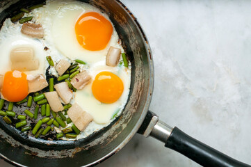 scrambled eggs with lard on a frying pan