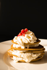 Banana pancakes with whipped cream and red currant