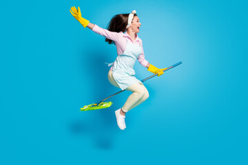 Fototapeta na wymiar Full length body size profile side view of her she nice attractive funky childish comic maid jumping riding broom like horse isolated on bright vivid shine vibrant blue color background