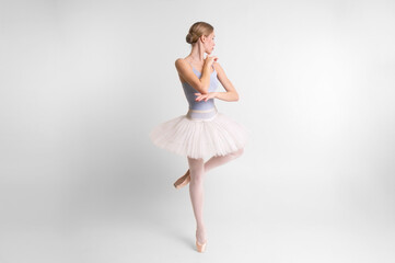 Fototapeta na wymiar Young beautiful ballerina dances in big studio isolated on white background