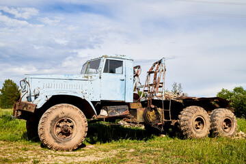 Fototapeta premium Dirty truck on a country green grass in a sunny summer day with blue sky.