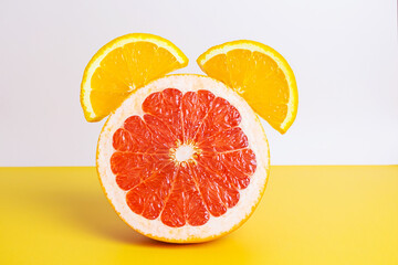 Sliced ripe grapefruit and orange in the shape of an alarm clock. Creative concept of vitality, awakening, vitamin C. Copyspace.