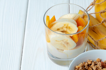 Tasty breakfast with granola, yoghurt and fruits in a glass bowl