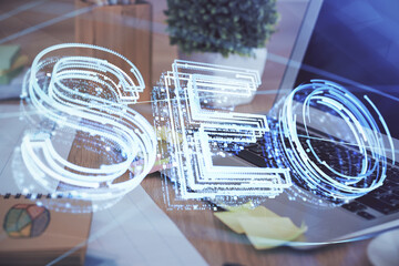 Multi exposure of table with computer and seo drawing hologram. Search optimization concept.