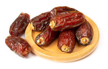 dried date palms in the wooden bowl, isolated on white background