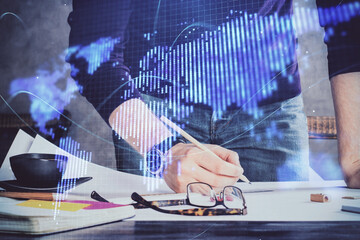 Double exposure of hands and notepad with business icons.