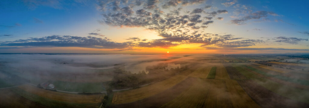 Beautiful morning with upraising fog over a panoramic field view at sunrise pure nature.