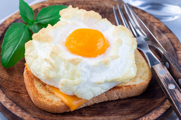 Trendy cloud or fluffy egg dish on a wooden plate, horizontal