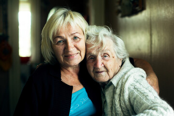 Portrait of mature woman together with her old mother.