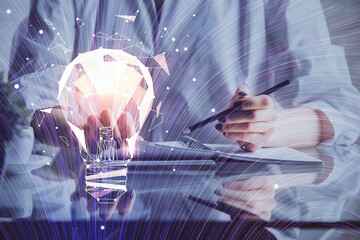 Drawing bulb over woman's hands taking notes background. Concept of idea. Double exposure