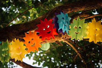 Guirlandes de soleil de couleurs festives accrochée à un arbre vert en été. Guirlande joyeuse...