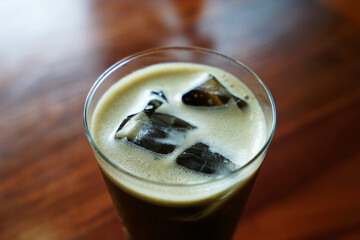 Close up glass of Iced Hojicha, Roasted Japanese green tea on wooden table