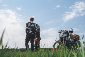 A pair of motorcyclists, man and woman. Loving couple of tourists. Relationship and adventure concept. A motorcycle with luggage, bags and a tent. Side bags. Active lifestyle.