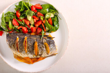 Orange sea bass fish baked on carrot, served