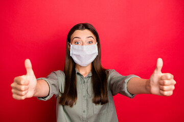 Close-up portrait of her she nice attractive healthy straight-haired girl wearing safety mask shirt giving two thumbup stop mers cov isolated bright vivid shine vibrant red color background