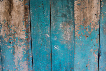 filled frame close up background wallpaper shot of an old ragged and scuffed blue turquoise painted wooden wall forming beautiful patterns and shapes