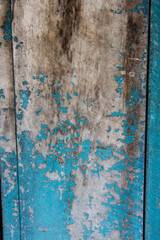 filled frame close up background wallpaper shot of an old ragged and scuffed blue turquoise painted wooden wall forming beautiful patterns and shapes