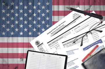 USCIS form I-140 Immigrant petition for alien workers lies on flat lay office table and ready to...