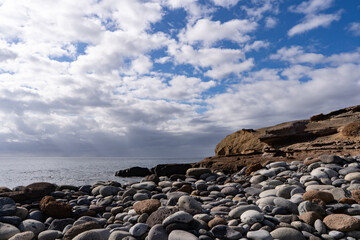 Playa de guijarros grandes junto al mar en un día nublado