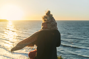 A young girl enjoys the sunset on the sea. View from the back. Kaliningrad region. High-quality...