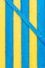 Une porte en bois jaune et bleue. Une façade de maison traditionnelle en bois jaune et bleu. Des lattes de couleurs comme le drapeau de la Suède.