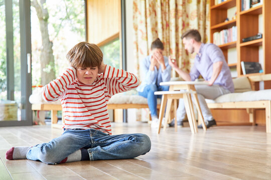 Boy covers his ears at the argument of the parents