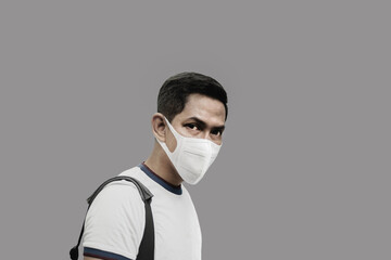 Portrait of man wearing protective mask in grey background during covid-19.