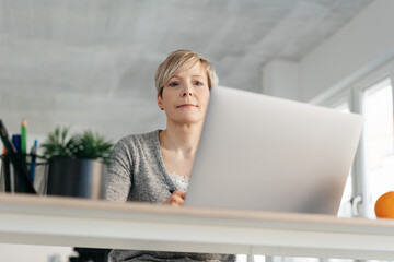 Thoughtful businesswoman looking down at camera