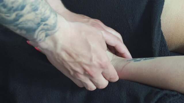 Male masseur makes palm massage hands for a young girl.