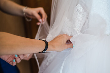 Obraz na płótnie Canvas bride in wedding dress, gathering the bride