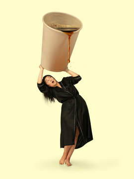 Gas up yourself, filling up with coffee to wake up. Creative artwork. Housewife in black wear holding huge cup with pouring coffee. Looks bored and tired, needs cistern of aroma drink to feel energy.