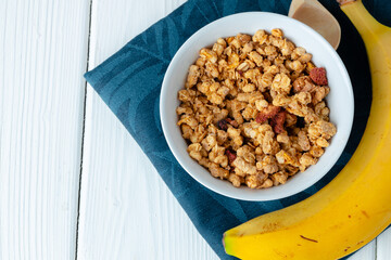Bowl with granola on wooden table close up