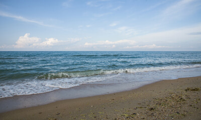 Fototapeta na wymiar Seascape. Blue sky, sea and yellow sand. Postcard with seascape. Copy space.