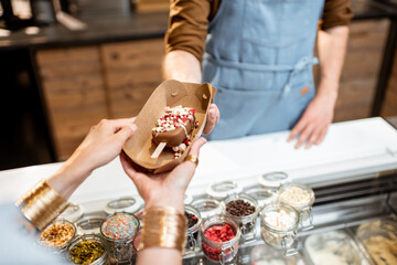 Buying or selling ice cream at the shop, close-up on chocolate ice cream