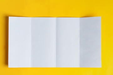 Four-fold brochure mockup above yellow background