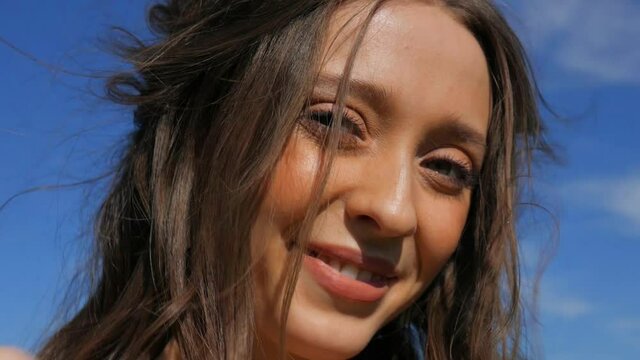 Beautiful happy girl. Young woman laughs at the camera. Summer, linen field, blue sky.