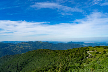 Naklejka premium Vistas desde la cima de la montaña a otras montañas y una carretera asfaltada de curvas