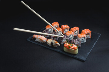 Set of traditional japanese food on a dark background. Sushi rolls. Asian food frame. Dinner party. 