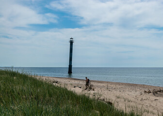 traditional summer landscape with sandy and pebbly promontory, green dune grass, abandoned sloping...