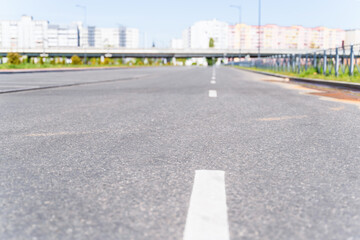 Empty  road  and road markings, city landscape background, focus to the foreground, blurred background