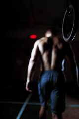 athlete man after exercise on gymnastic rings. man out of focus. Focus on ring
