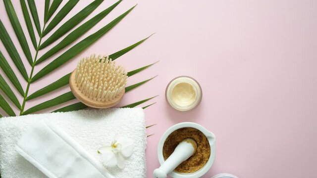 Spa still life composition. White towel and tropical palm leave on the pink background