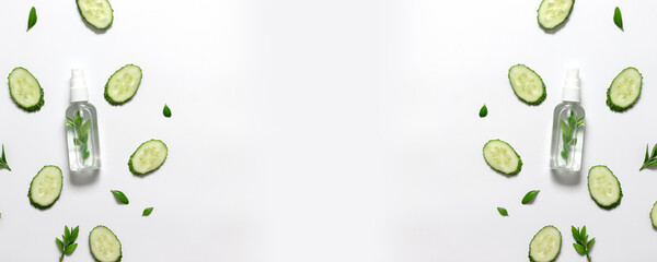 Natural lotion in plastic bottle, slices of cucumber laid out all over the background. Concept of natural body oil, fresh perfume, cosmetics, body care. Flat lay, top view, copy space