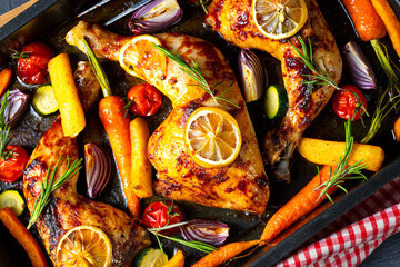 Grilled chicken legs with various vegetables and herbs.