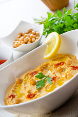 hummus paste with lemon and chilli on white background