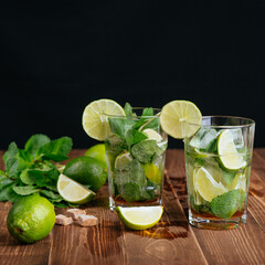 mojito cocktail with lime and mint on black background